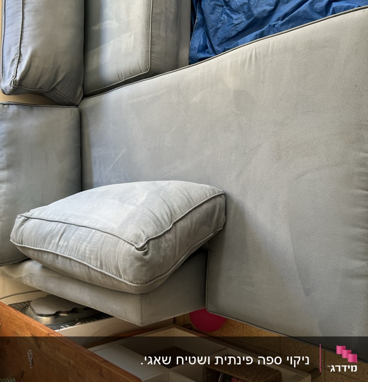 ספה כחולה עם כריות על רצפה מרוצפת